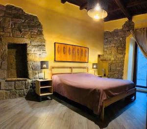 维泰博Al Cardinale的一间卧室设有一张大床和石墙