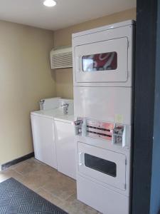 奥德萨Howard Johnson by Wyndham Odessa TX的厨房配有白色冰箱和炉灶。