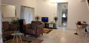 万挠Tun Perak Homestay的客厅配有两把椅子和电视