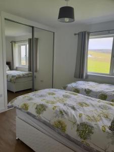 FinstownCottiscarth Cottages的一间卧室设有两张床和大窗户