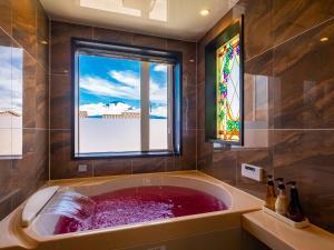 富士河口湖太阳别墅的一间带大浴缸及窗户的浴室