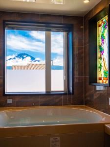 富士河口湖太阳别墅的带浴缸的浴室和窗户