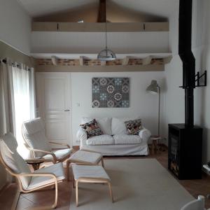 埃梅Petit Gite Eymet的客厅配有白色的沙发和椅子