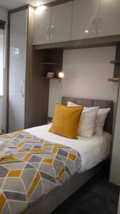 New BedfontThe Hatton Rooms的一间卧室配有一张黄色枕头的床