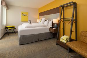圣地亚哥Staypineapple, Hotel Z, Gaslamp San Diego的配有一张床和一把椅子的酒店客房