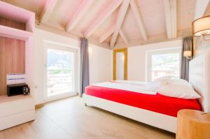 托尔博莱Casa Tosca - Holiday Home的卧室设有红色和白色的床和窗户。