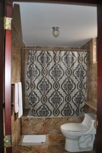 拉塔昆加MAK INN HOUSE的一间带卫生间和墙壁的浴室