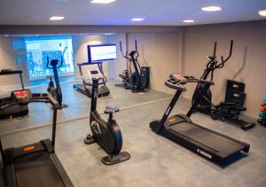 马塞约Acqua Suítes Maceió的健身房设有数辆健身自行车和电视