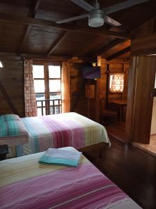 博卡斯德尔托罗Hostal Hansi的小屋内一间卧室,配有两张床