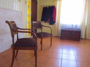 塔尔卡瓦诺La Casa del Viento的一间设有两把椅子和一个衣柜的房间