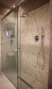 卡塔尼亚Scene Suites Apartments的带淋浴的浴室和玻璃门