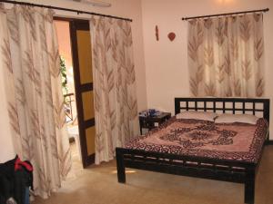 瓦加托Bethany Inn的一间卧室配有床和窗帘的门