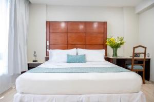 墨西哥城Suites Coben Apartamentos Amueblados的卧室配有一张白色大床和木制床头板