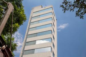 墨西哥城Suites Coben Apartamentos Amueblados的一面是一座高大的建筑,一面是玻璃窗户