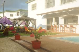 阿比让赫利俄斯公寓酒店的一个带桌椅的庭院和一个游泳池