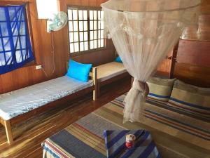 罗哈斯Modessa Island的客房设有2张长椅和带窗帘的窗户。