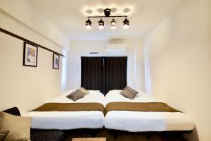 冲绳岛市Allstay GOYA的带窗户的客房内的两张床