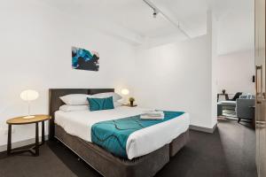 墨尔本码头私人收藏 - 数码港酒店的一间卧室配有一张大床和一把椅子