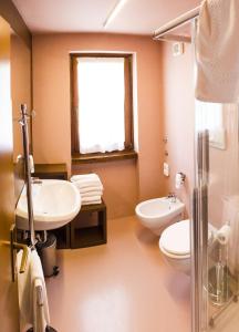 福尔加里亚Hotel Villaggio Nevada的一间带水槽和卫生间的浴室以及窗户。