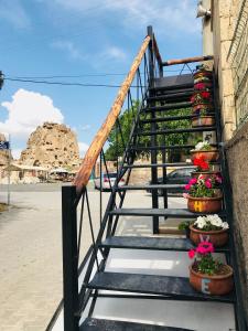 乌奇希萨尔Sakli Konak Cappadocia Hotel&Restaurant的建筑一侧有盆栽植物的楼梯
