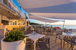 弗尔萨尔Victoria Mobilehome in Orsera Camping Resort的海滩上的餐厅,配有桌椅