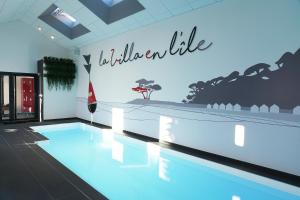 诺亚芒提亚La Villa en L'île - 2 Piscines & Spa的一座带标志的建筑中的游泳池,上面写着: