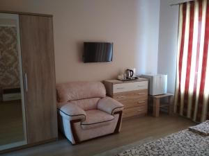 敖德萨Hotel Elita的卧室配有椅子和墙上的电视