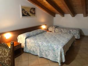 LuniAlbergo Antica Luni的一间酒店客房,房间内设有两张床