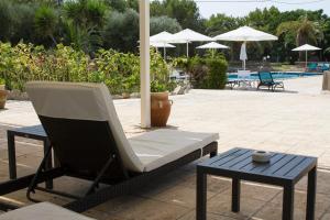 圣凯撒利亚温泉Residence Conchiglia San Giovanni的庭院配有椅子、桌子和遮阳伞