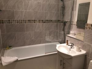 南安普敦10号服务公寓 - 丹尼斯的浴室配有盥洗盆、浴缸和盥洗盆