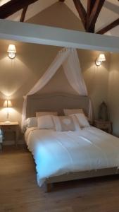 Neufmoutiers-en-BrieChambres d'hôtes La Bourbelle的一间卧室配有一张带天蓬的白色床