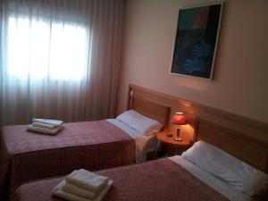 圣塞巴斯蒂安德洛斯雷耶斯若望二十三世旅馆的酒店客房设有两张床和窗户。