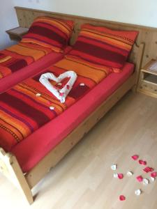 La Ferrière洛吉斯德拉利科恩酒店的一张带红橙色毯子和一些药片的床