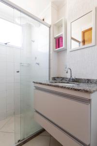 圣卡洛斯Spot Residence São Carlos 700m da USP的白色的浴室设有水槽和淋浴。