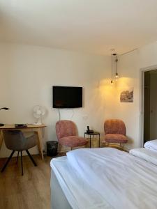 霍尔斯特布罗绍姆堡酒店的一间卧室配有一张床、两把椅子和一张书桌