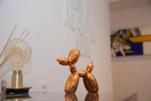 那不勒斯Cocor Suites & Design的灯泡旁桌子上的一只狗的金雕