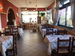 LuniAlbergo Antica Luni的一间设有几张桌子和椅子的餐厅以及一间设有桌椅的房间