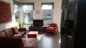 阿姆斯特丹维根伯斯船屋的客厅配有沙发、两把椅子和电视