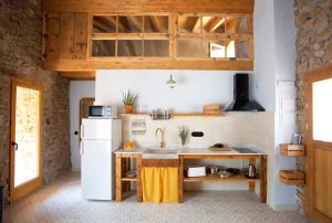 ArsèguelEl Mas de Sant Vicenç - apartamentos rurales的厨房配有白色冰箱和木制橱柜。