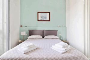 米兰Isola View Renovated Apartment的一间卧室配有一张带两条白色毛巾的床