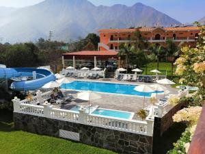 卢那欢纳Lunahuana River Resort的一座带游泳池和大楼的度假村