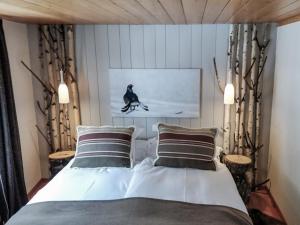 圣吕克法夫雷木屋大酒店的卧室配有一张床和鸟的照片