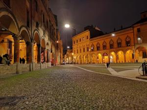 博洛尼亚Casa Santo Stefano的一条空荡荡荡的城市街道,晚上有建筑
