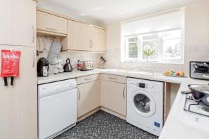 格雷斯瑟罗克Thurrock, Grays -Spacious 3bd 3bath House Lakeside的白色的厨房配有洗衣机和烘干机