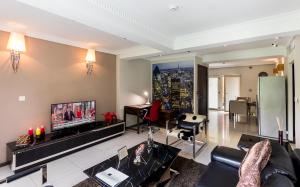 塔科拉迪Red Mango Hotel and Apartments的带沙发和电视的客厅