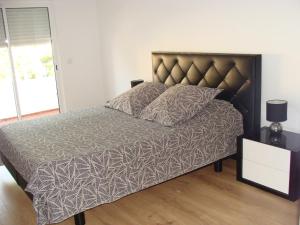 法鲁Casa do Largo的一间卧室配有一张大床和棕色床头板