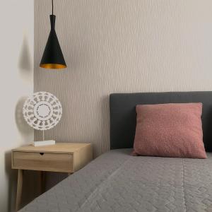 蒂萨凯奇凯Aranypart Apartmanházak Tiszakécske的一间卧室配有一张带粉红色枕头和灯的床