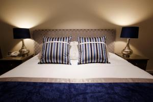 金斯克利尔桑福德温泉酒店及高尔夫俱乐部的一张带两个枕头的床和两盏灯