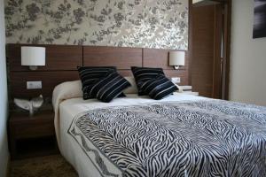博伊罗尼克森乡村酒店的一间卧室配有一张带黑白床单和枕头的床。