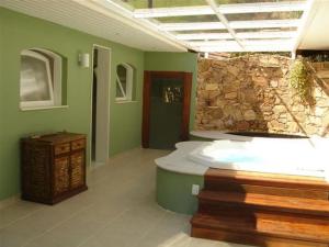 伊泰帕瓦Pousada Quinta dos Pássaros Itaipava的一间设有石墙和浴缸的大浴室